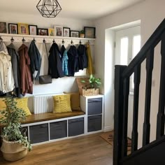 the entryway is clean and organized with coats on hooks, clothes hangers, and storage bins