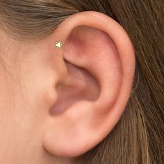 a woman's ear is shown with a small diamond in the middle of it