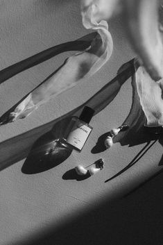 a black and white photo of an umbrella, shoelaces, and perfume bottle