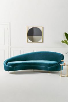 a green couch sitting next to a plant in a living room