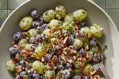 a bowl filled with blueberries and brussel sprouts next to a spoon