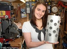 a woman holding up a can in her workshop