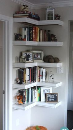 there is a bookshelf with many books on it in the corner and some pumpkins