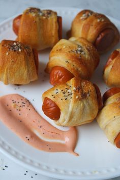 hotdogs wrapped in bread on a white plate