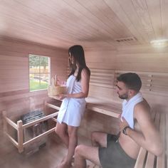 a man and woman sitting in a sauna