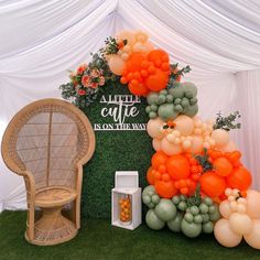 an orange and white balloon arch is on display