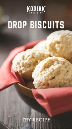 three biscuits in a bowl on top of a wooden table with the title kodiak drop biscuits try recipe