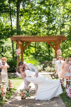 a bride and groom kissing in front of an outdoor ceremony