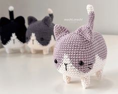 small crocheted cat figurines are lined up on a white countertop