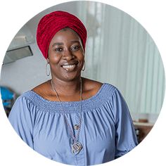 a woman wearing a red turban smiles at the camera