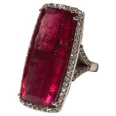 Description This striking 25.5 carat elongated emerald cut Red Tourmaline ring is embellished with 1.32 carats pave diamonds, and is set in a 14k white gold Y-shape band. Item #R180 Materials and Weight Red Tourmaline 25.5 cts 31.2x13.8x7.1mm, elongated emerald cut. Diamonds 1.32 cts 14k white gold Dimensions Size 7 Band width 3mm Made in Newport Beach, California. USA Lannister Fashion, House Lannister, Red Tourmaline, Newport Beach California, Rubellite Tourmaline, Pave Diamond Ring, Bracelet Love, Diamonds Ring, Tourmaline Ring