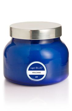 a blue jar with a silver lid on a white surface