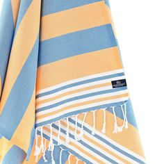 an orange and blue striped towel folded on top of each other with fringes around the edges