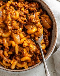 a bowl filled with macaroni and cheese on top of a white table cloth