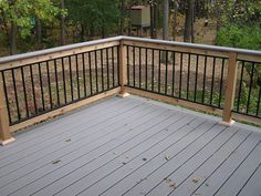 a wooden deck with metal railings in the woods