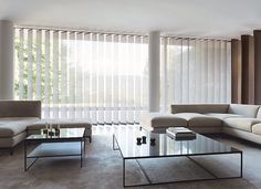 a living room with couches, tables and blinds in the window sill area