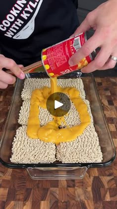 someone is pouring mustard on top of some rice krispy kreme treats in a pan