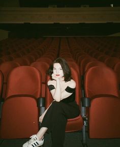 a woman is sitting in an empty theater