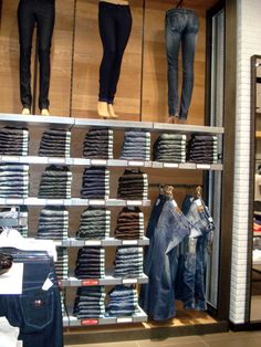 several pairs of jeans are on display in a clothing store