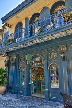 an ornate building with blue doors and balconys on the second floor is decorated with flowers