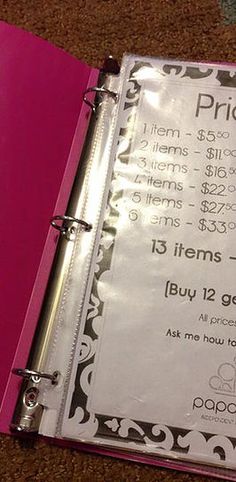 a pink binder sitting on top of a table next to an open planner book