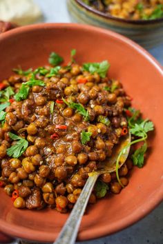 a bowl filled with cooked chickpeas and garnished with cilantro