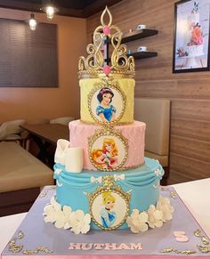 there is a three layer cake with princesses on it