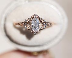 a close up view of a ring with a diamond in the middle and two smaller diamonds on each side