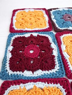 four square crocheted grannys are arranged on a table