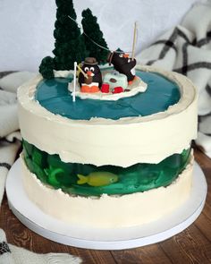 there is a cake that has been decorated with animals on the boat and trees in the water