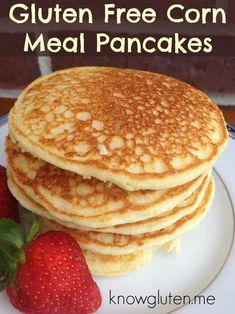 pancakes stacked on top of each other with strawberries next to them and text overlay that reads gluten free corn meal pancakes