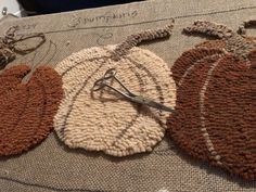 three pieces of crocheted fabric with scissors on them sitting on top of a table