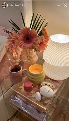 a glass table topped with lots of different types of items next to a vase filled with flowers