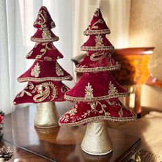 two red christmas trees sitting on top of a wooden table