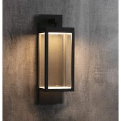 a wall mounted light that is on the side of a building with concrete walls behind it