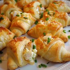 several pastries on a white plate with green onions