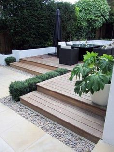 an outdoor patio with wooden steps and plants