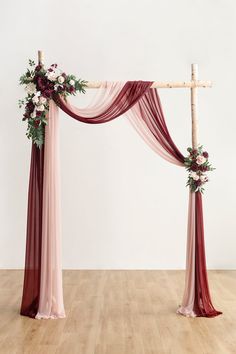 a wedding arch decorated with flowers and greenery