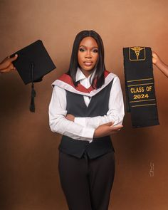 a woman in graduation gown holding up her class of 2020 stoler and black hat