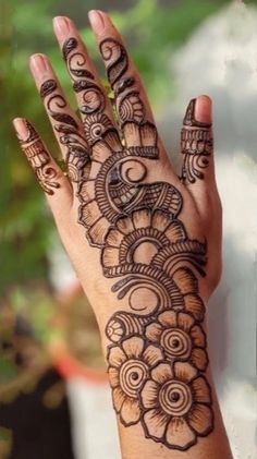 a woman's hand with henna tattoos on it