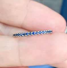 "Blue Sapphire Pave Full Eternity Wedding Band. MaterialSolid Gold (14K/18K) or Platinum 950 FinishingHigh Polished/Shiny PlatingRhodium/Platinum Family (Only if white gold selected) FitComfort Fit/Rounded Interior Width1.7mm Height1.7mm SettingU Micro Pave (Reminds the letter \"U\" from sides) StonesNatural Sapphires ColorBlue QualityAAA Cut and ShapeRound/Diamond Cut Total Carat Weightapx 0.53 carat Quantity of Stonesapx 38 Click below to add laser engraving. https://www.etsy.com/listing/63107 Blue Eternity Band With Prong Setting For Anniversary, Blue Prong-set Eternity Band For Anniversary, Blue Round Cut Eternity Band For Anniversary, Blue Anniversary Eternity Band, Blue Eternity Band For Promise, Blue Sapphire Eternity Band As Gift, Blue Eternity Band With Vvs Clarity For Anniversary, Blue Stackable Eternity Band For Anniversary, Blue Round Eternity Band With Prong Setting