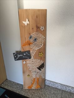 a wooden sign with an image of a bird on it's side and a chalkboard attached to it