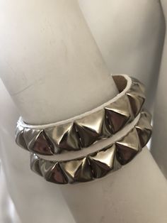 "Classic punk bracelet with two rows of pyramid studs. Studs are 1/2\" across. Studs are steel with nickel plating, hardware is brass with nickel plating. Made with hand dyed vegetable tan leather. Pink sparkle leather is an additional coating applied over dyed leather and may flake off a little around where the buckle fastens. Note: 5.5\"-6.25\" and 6.5-7.25\" bracelets have snaps instead of buckles. The studs are closer together on these than the other bracelet, see pix for details. For best r Adjustable Silver Bracelet With Spikes, Metal Spiked Leather Bracelet For Parties, Edgy Silver Leather Bracelet With Spikes, Silver Punk Bracelets With Studs, Adjustable Metal Bracelets With Studs, Punk Style Silver Bracelet With Studs, Silver Leather Bracelet With Rivets For Party, Edgy Silver Leather Bracelet With Studs, Punk Silver Leather Bracelet With Studs