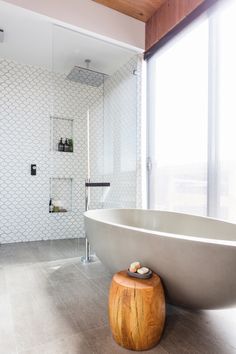 a large white bath tub sitting next to a window