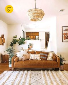 a living room with a couch, rug and potted plants in it's center