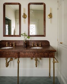 a bathroom with two sinks and mirrors on the wall