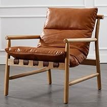 a brown leather chair sitting on top of a hard wood floor next to a white wall