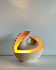 a light that is sitting on top of a table in front of a white wall