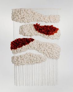 three pieces of art hanging on a wall with red and white yarn attached to it