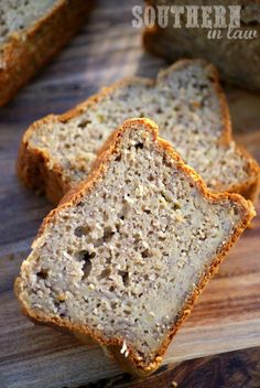 two slices of banana bread on a cutting board next to some other pieces of bread